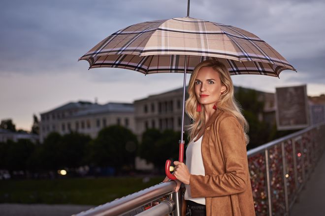 Ein Schirm mit Karomuster und Ledergriff ist ein eleganter Begleiter auf Reisen und im Alltag.